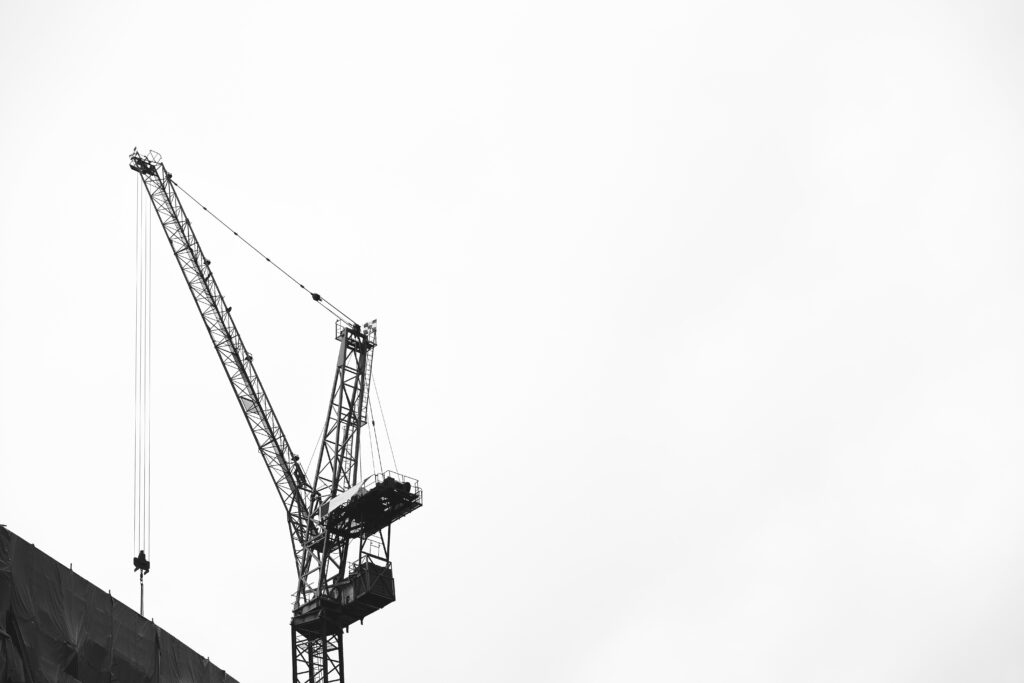 Kraanoperator op bouwplaats bedient hefwerktuig via draadloze afstandsbediening voor veilige en efficiënte werking